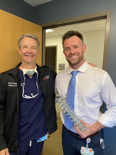 Dr. Phillip Behrens and a colleague holding a spine model